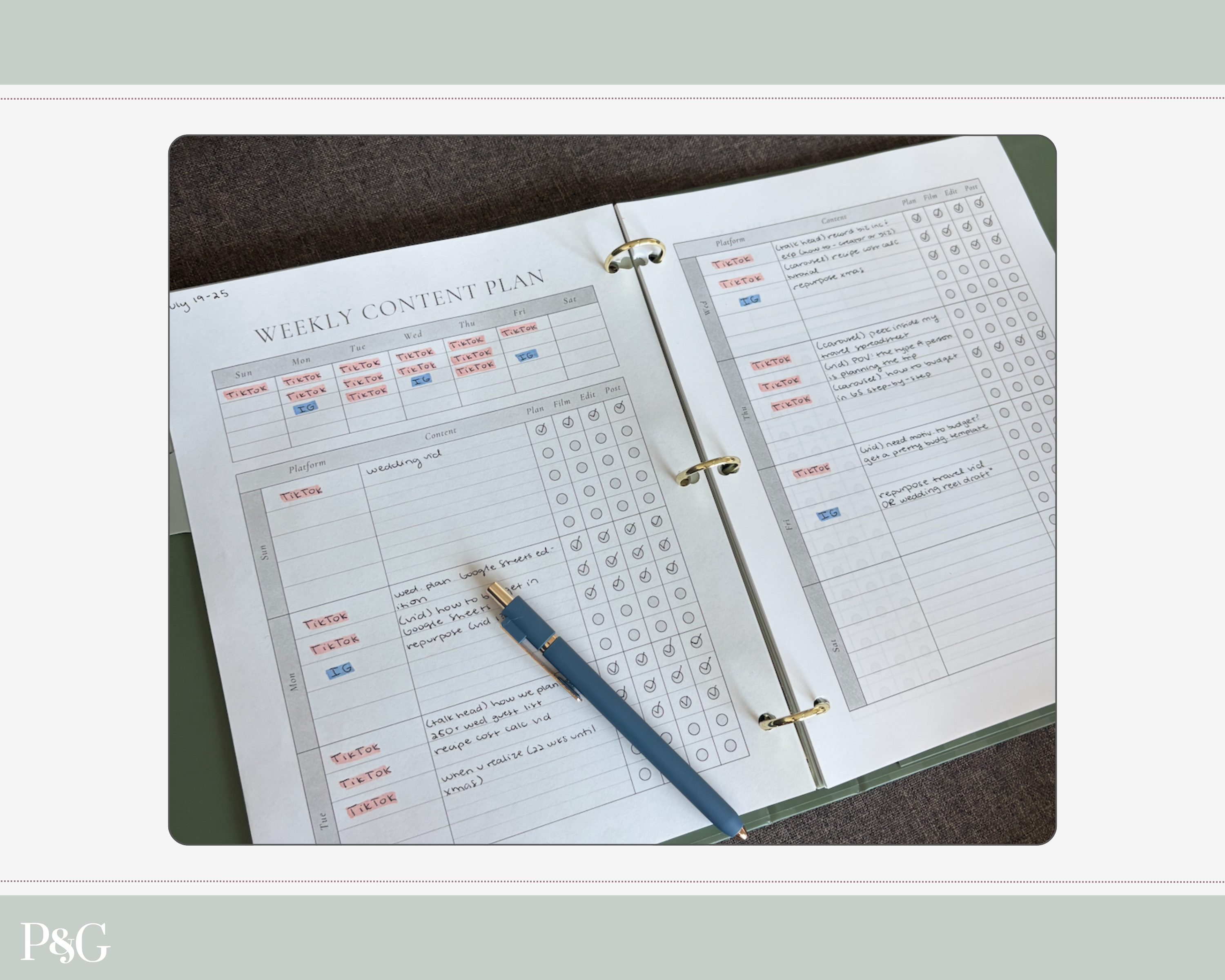 An open three-ring binder weekly content plan planner, showing printed tables and checkboxes, with a blue pen resting on the page, photographed from above on a dark surface.